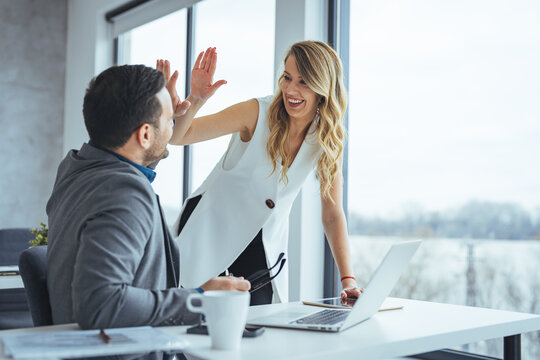 Colleagues Celebrating Success with a High Five in Modern Office