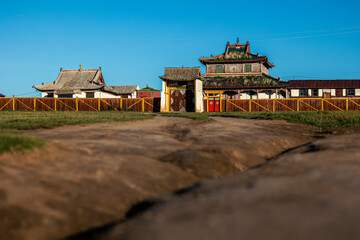 mongolian monastery at sunrise with country road in the foreground