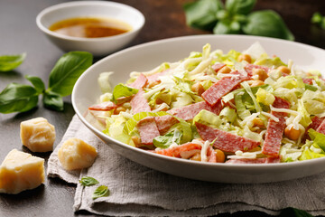 La Scala Salad with romaine lettuce, salami, mozzarella cheese and chickpeas in white plate.