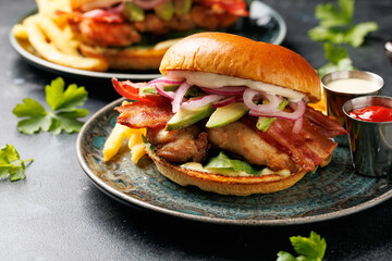 Chicken sandwich, burger with bacon, pickled onion, avocado, mayonnaise and french fries