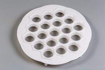 Plastic dumpling mold on a gray background