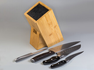 Bamboo stand for kitchen knives and several knives on foreground
