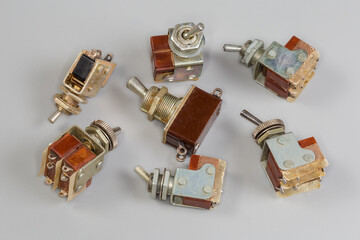 Different old electrical toggle switches on a gray background
