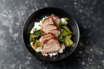 Chinese BBQ Pork Char Siu with rice and bok choy in a black bowl