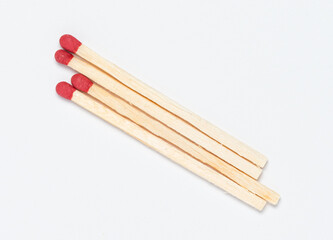 Matchsticks with red tip on white background, close-up top view from above
