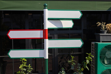 Colorful directional signpost in urban setting guides visitors to various locations © Alina