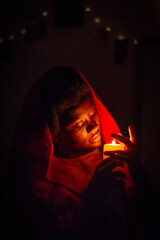 Keep Your Lamps Burning.A young woman holding a candle in the dark