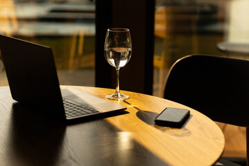 workplace, laptop, mobile phone and a glass of water on the table