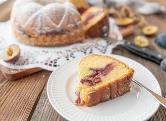 Delicious homemade plum bundt cake on rustic and wooden table background.