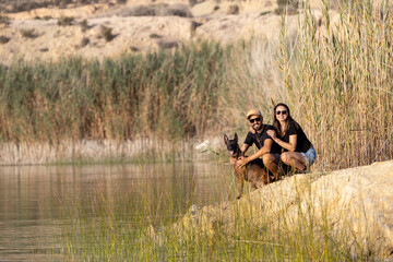 Happy couple with a dog in a lake