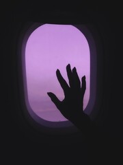silhouette of a hand in airplane window