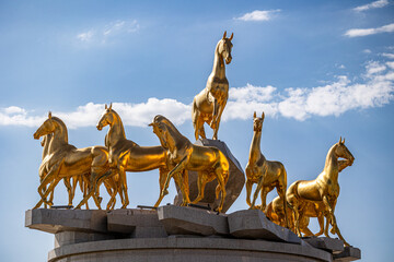 golden horses herd statue turkmenistan blue sky