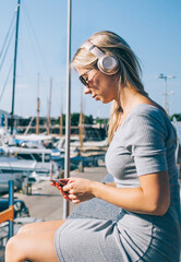 Woman in headphones on city seafront