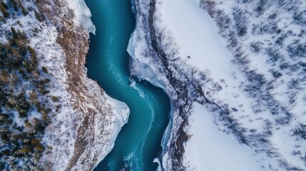 Aerial view of a winding river through snowy landscapes and icy formations.