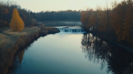 A serene landscape featuring a river, waterfall, and autumn foliage reflecting in the water.