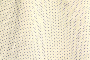 Close-up of a piece of white cotton fabric with a pattern