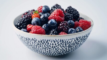 A bowl of mixed berries (strawberries, blueberries, raspberries, blackberries) overflowing with freshness