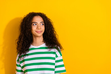 Photo of nice young girl look empty space wear striped t-shirt isolated on yellow color background