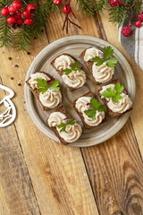 Christmas appetizer New year meal idea. Creative appetizer christmas. Creamy pate sandwiches of herring on a rye bread on the rustic table.