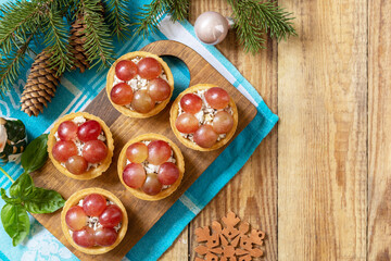 Creative appetizers christmas. Tartlets with chicken and grapes on the festive table on a rustic table.