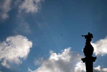 Fototapeta premium Statue of Columbus Pointing Towards the Sea in Barcelona Under a Cloudy Sky