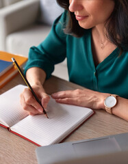 donna che prende appunti a penna su quaderno 