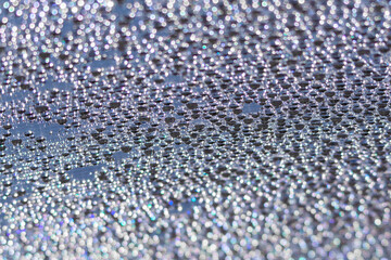 Blue water droplets on a piece of polycarbonate. Abstract background