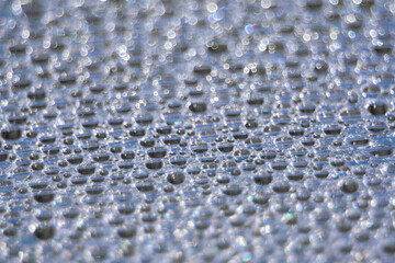Blue water droplets on a piece of polycarbonate. Abstract background