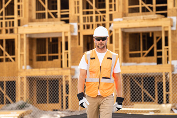 roofer builder working on roog structure of building on construction site. handsome young male...
