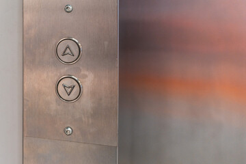 Elevator control panel. Up and down buttons on the steel surface.