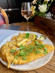 Fish and chips in a London pub with a glass of wine