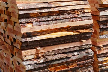 Rows of planks, close-up. Stacked on top of each other, each with straight edges and smooth wood grain. Texture of the planks, wood grain. Shades of wood. Ready to use for construction and decoration.