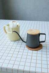 yellow cup freshly brewed coffee with convenient drip filter on kitchen table. prepare freshly brewed coffee at home. Space place for text. concept of making hot drink. bag of drip coffee beans.