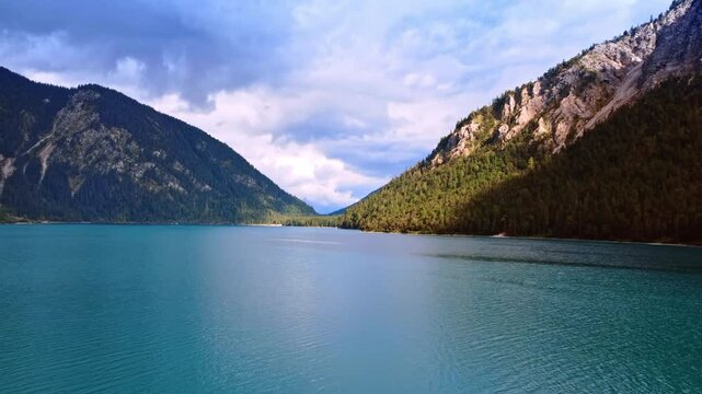 Calm beautiful cityscape of blue lake surrounded by high mountains. Waterscape in Lichtenstein in wild nature.