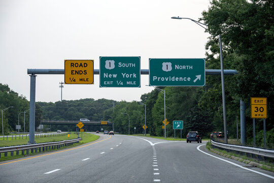 Directional signs at an intersection with arrows to Providence and New York.