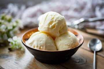 Creamy ice cream in a plate on a wooden table. Homemade ice cream for dessert. Close-up