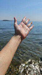 Hand extended forward to the sea