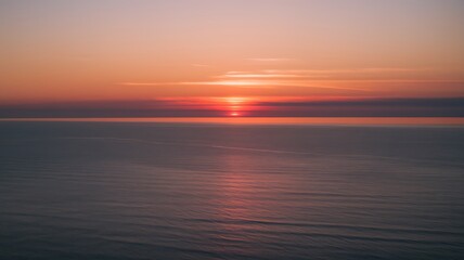Fototapeta premium sun setting over ocean with tranquil waves and vibrant colors at twilight