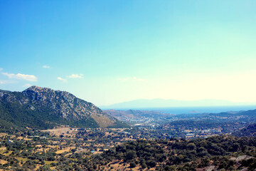 Blue sky, mountain and forest on landscape outdoor with sea coast, nature and mockup space in Turkey. Woods, hills and trees with city buildings or houses by ocean for tourism location and holiday