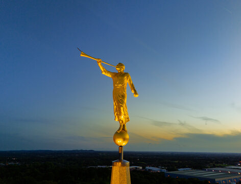 Chorley, Lancashire, UK, July 26, 2024; close up aerial view of Angel Moroni with sunset background on the Preston England Temple Church of Latter Day Saints, Chorley Lancashire England