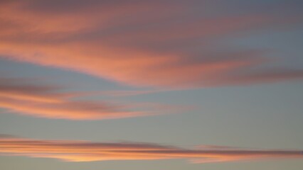 Fototapeta premium A serene sky filled with soft pink and blue clouds at dusk.