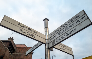 A street sign directing people to various important services and places of interests in the area.