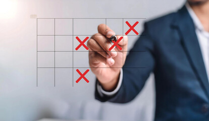Businessperson marking a tic-tac-toe grid on a transparent surface.
