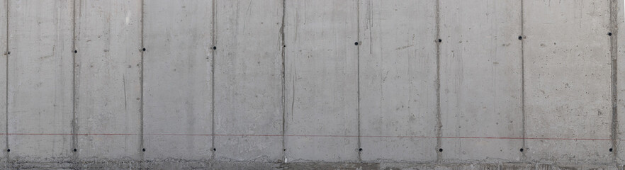 Textura panorámica, de pared de cemento liso con líneas verticales en tonos gris oscuro