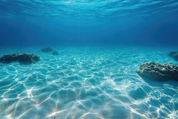 Sunlight shining on rocks on the seabed in blue ocean water