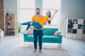 Full size photo of two young partners hold arms wave hi free time modern interior apartment indoors