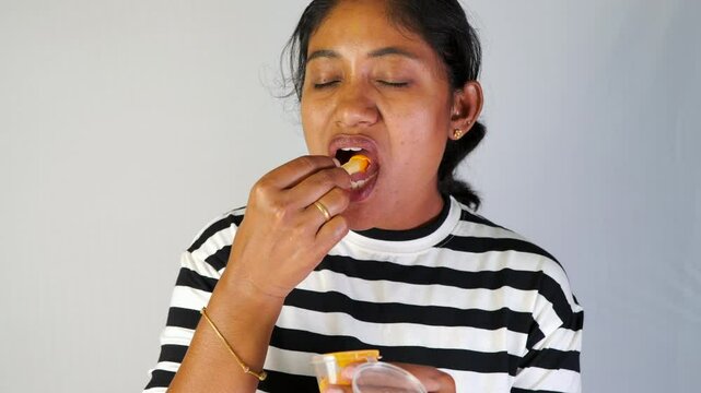 An indian women eating fench fries in white background