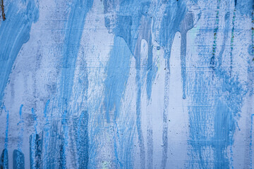 Messy paint strokes and smudges on grunge purple painted wall background. Creative modern urban...
