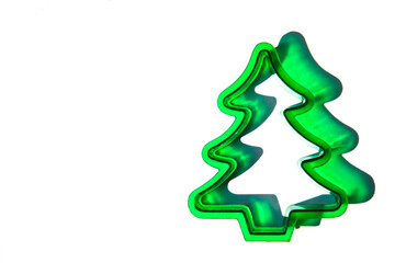 flat lay close-up of a green Christmas tree cookie cutter against a white background with copy space available