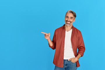 Happy older casual man of middle age pointing finger aside advertising promo. Smiling mid male guy...